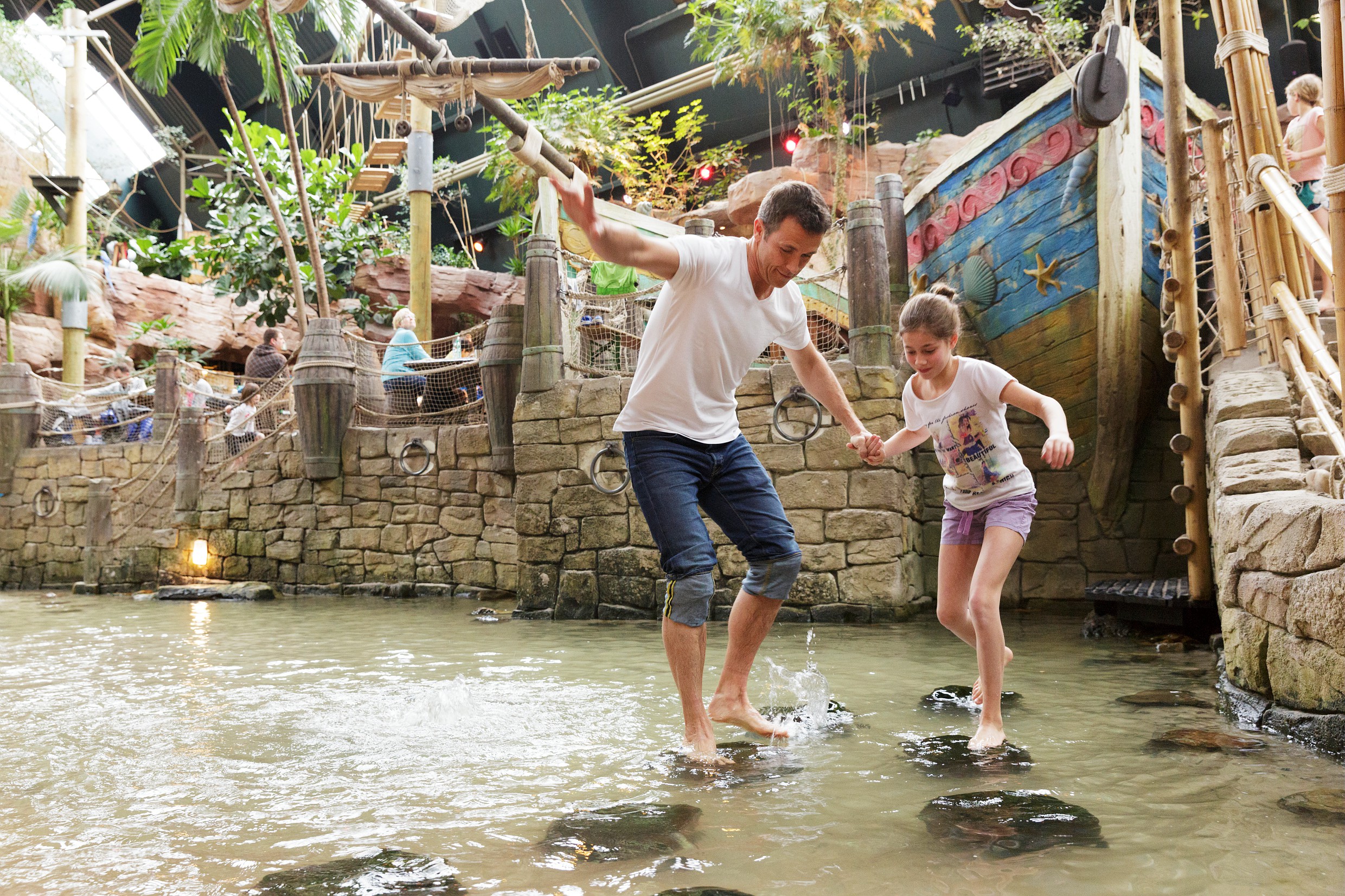 papa en dochter lopen over keien op het water