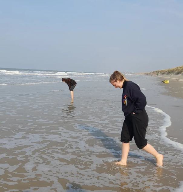 twee mensen die met voeten in de zee zitten