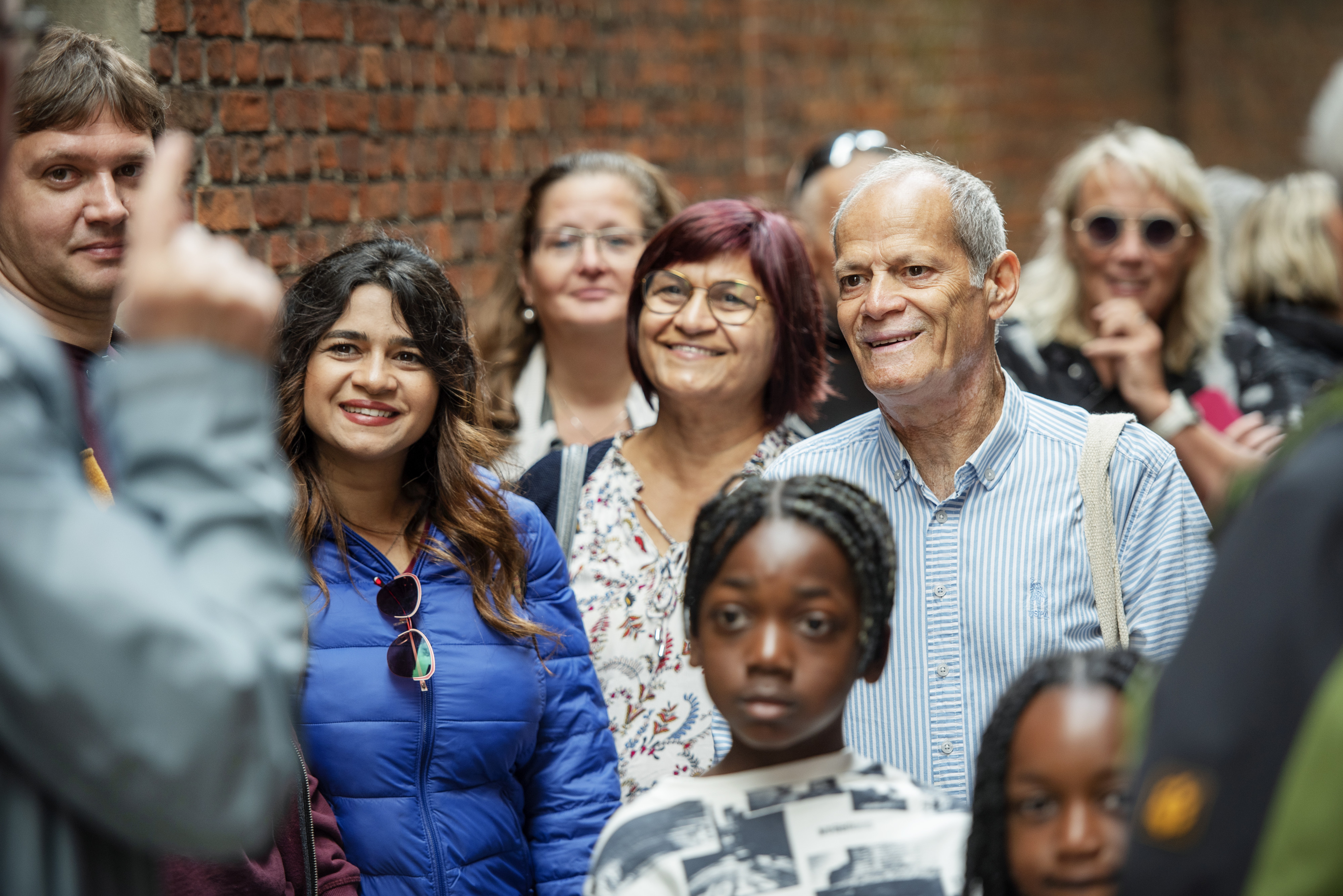 groep mensen die uitleg krijgen van een gids, we zien kinderen, volwassenen en ouderen