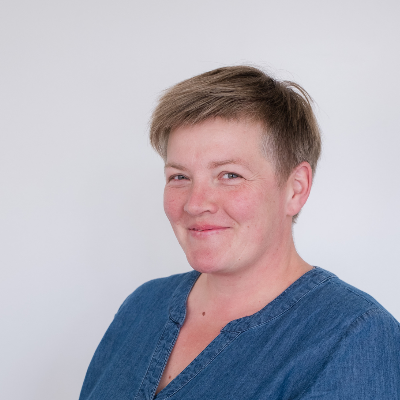 dame met kort bruin haar en blauw jeanskleedje