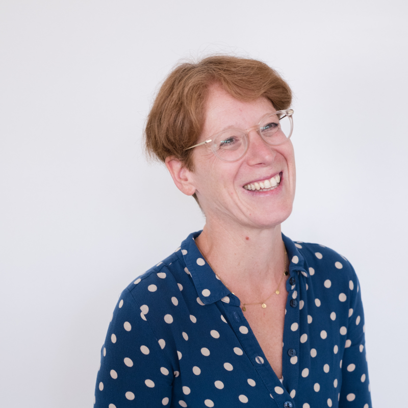 dame met kort ros haar en blauw kleedje met witte stippen
